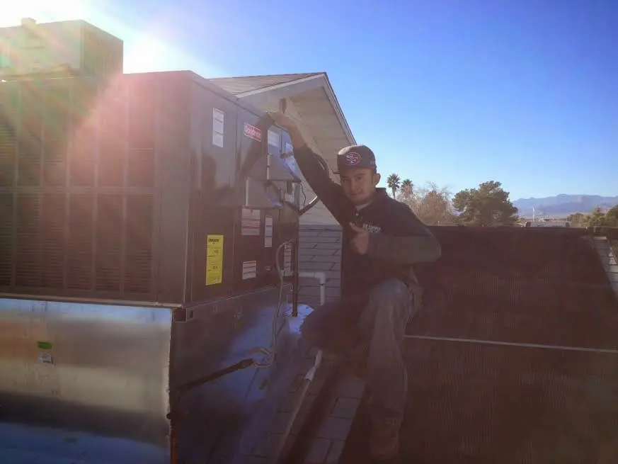 HVAC technician performing HVAC Inspection on a rooftop unit in Hudson Falls